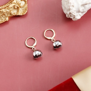 Detailed view of festive gold hoop earrings with polished silver bell pendants for women