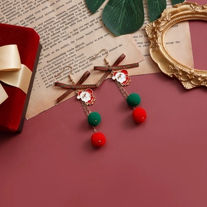 Dettaglio degli orecchini di Babbo Natale con fiocchi e pompon su una scatola di velluto