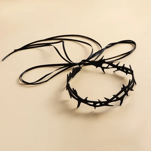 Close-up of black gothic thorn choker with matte finish and long silk ribbons