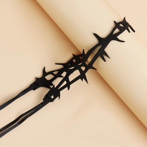 Detail of gothic black thorn choker necklace featuring sharp spikes and adjustable fabric ties