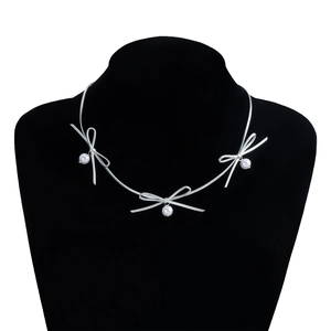 Zilveren strik choker ketting met witte parelhangers gepresenteerd op een zwarte buste