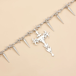 Macro detail of silver thorn chain necklace with spikes and large gothic cross pendant