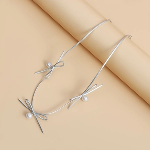 Detail van de zilveren kunstlederen choker met parelstrikken op een displaystandaard