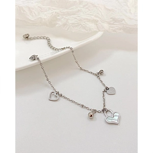 Détail du bracelet en acier argenté avec cœur en nacre et breloque gravée Love