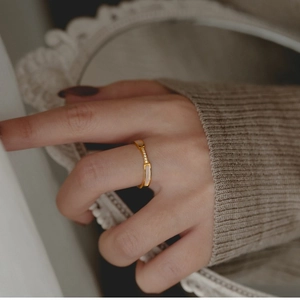 Eleganter Ring aus roségoldenem Titanstahl mit Mikro-Pavee-Muscheleinlagen an der Hand