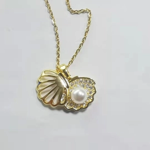 Dettaglio del ciondolo a conchiglia placcato oro 18k con perla e micro-pave di zirconi