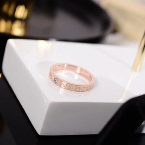 Detalle de anillo de titanio oro rosa con grabado Forever Love y un pequeño circón