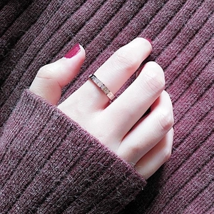 Primer plano de un anillo de acero de titanio pulido con grabado Forever Love en el dedo