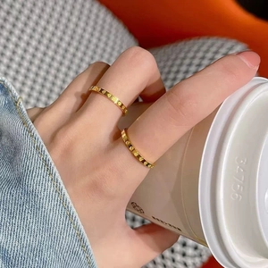 Nahaufnahme minimalistischer Goldringe mit Herzmuster an den Fingern einer Frau