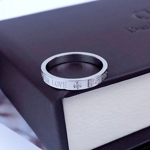 Primer plano de anillo de acero plateado con grabado Forever Love y circón pequeño