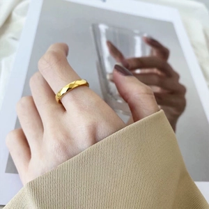 Nahaufnahme eines goldenen Rings mit gesteppter Textur und geometrischen Facetten