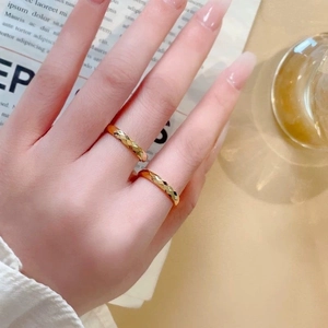 Detailansicht von zwei goldfarbenen, facettierten geometrischen Ringen am Finger