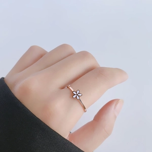 Minimalist 18k rose gold daisy flower ring for women shown on a finger macro view