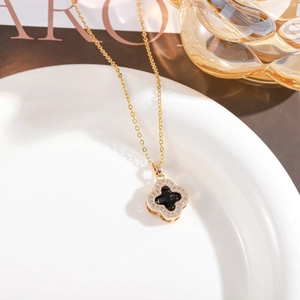 Detail of clover sweater chain featuring black inlay and sparkling zirconia stones