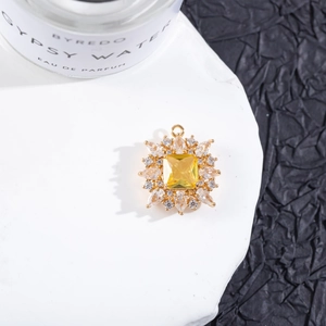 Primer plano de colgante dorado con cristal amarillo cuadrado y pavé de circonitas