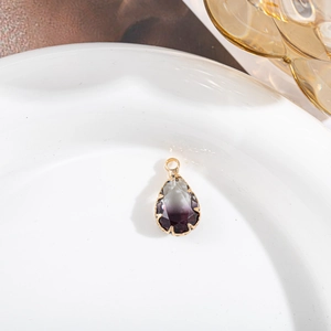 Gros plan d'un pendentif en cristal poire avec dégradé violet et monture dorée