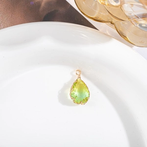 Détail macro du pendentif en cristal en forme de larme avec serti à griffes dorées sur assiette
