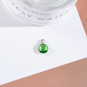 Macro detail of emerald green faceted crystal pendant with silver setting for jewelry