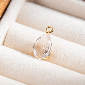 Vue macro d'un pendentif goutte en cristal transparent avec sertissage doré