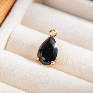 Vue macro d'un pendentif en cristal noir facetté avec serti à griffes en métal doré