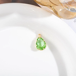 Vue détaillée du pendentif cristal goutte verte avec serti à griffes plaqué or
