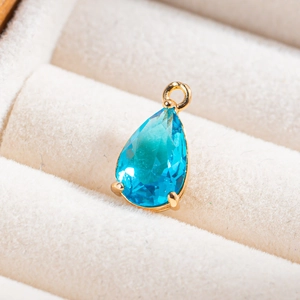 Gros plan d'un pendentif en cristal bleu ciel en forme de goutte pour bijoux artisanaux