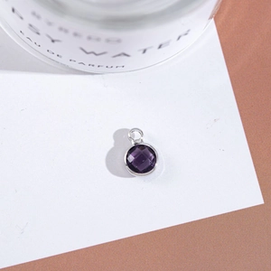 Detailed close-up of a purple faceted crystal pendant with silver plated bezel setting