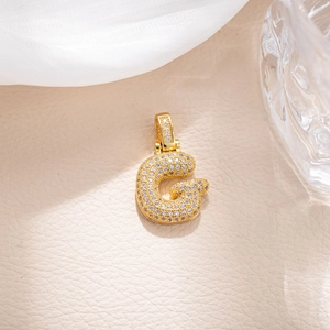 Close-up of gold plated letter G pendant with sparkling zircon micro-pave setting