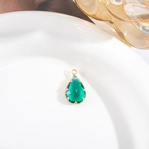 Détail d'un pendentif en pierre verte en forme de goutte avec sertissage à griffes dorées