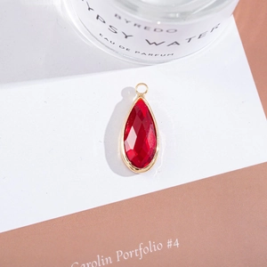 Macro view of teardrop red crystal pendant with gold plating for jewelry making