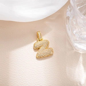 Close-up of golden bubble letter Z pendant with micro-paved sparkling cubic zirconia