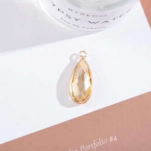 Macro shot of gold-plated teardrop pendant with a champagne faceted crystal inlay
