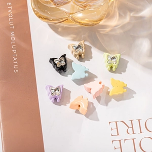 Detailed macro shot of mini resin butterfly hair clips with sparkling rhinestones
