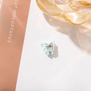 Detail of light blue butterfly hair accessory featuring a large faceted clear crystal stone