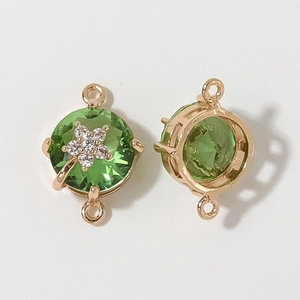 Macro detail of gold plated round green crystal connector with small zircon flower charms