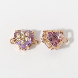 Vista detallada del colgante corazón dorado con piedra púrpura e incrustación floral