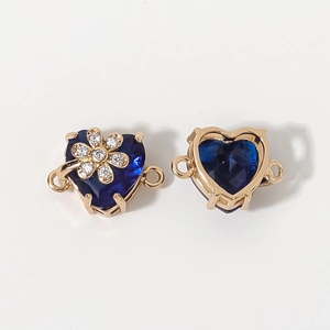 Vista macro detallada del colgante de corazón con gema azul oscuro y base de metal dorado