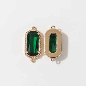 Dettaglio del pendente con gemma sfaccettata verde scuro e montatura in metallo dorato