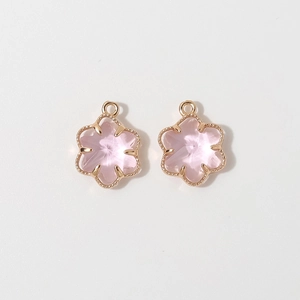 Detailed macro of pink six-petal flower pendants with gold milgrain frames for jewelry DIY