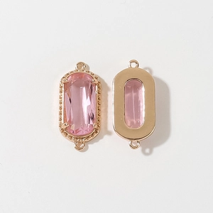 Dettaglio del connettore ovale placcato oro con cristallo rosa per creazione di gioielli