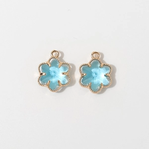 Detail of 12mm light blue floral crystal pendant with gold-plated scalloped metal edge