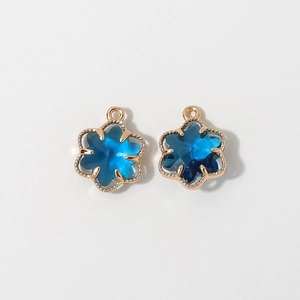 Detailed view of 12mm blue crystal flower charms with gold-plated copper claw frames
