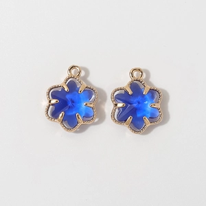 Detailed close-up of 12mm gold-plated six-petal flower pendants with deep blue crystals