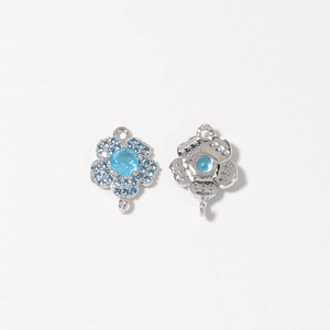 Vue macro détaillée de charmes en forme de fleur à cinq pétales avec zircon bleu et boucles