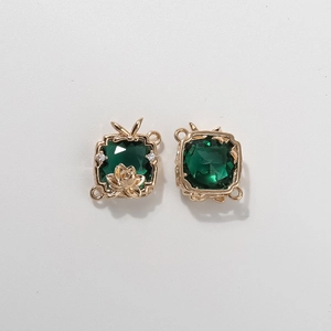Detailed macro of square dark green faceted gemstones with ornate gold floral metal frame
