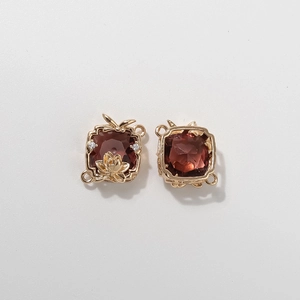 Detail of vintage square silk scarf buckle with red garnet stone and gold lotus motif