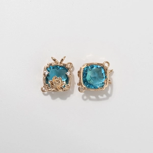 Macro shot of gold lotus charm with square blue gemstone for silk scarf ring