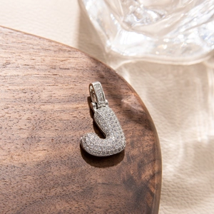 Macro shot of silver hip hop pendant letter J featuring micro-pave cubic zirconia stones