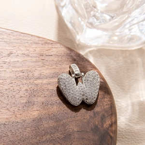 Macro shot of micro-pave cubic zirconia heart pendant on a wooden jewelry display stand
