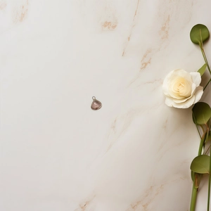 Detail of pink crystal teardrop pendant with silver trim on marble background